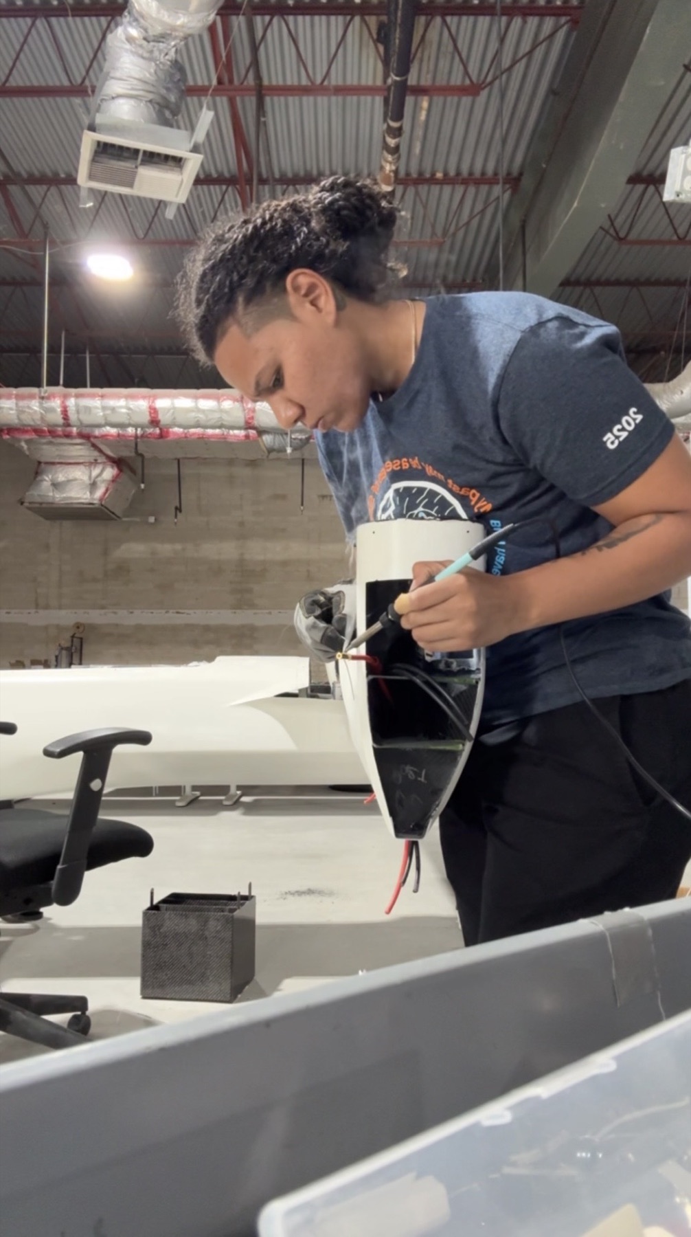 Lauren Session soldering an electrical connection on an aircraft assembly